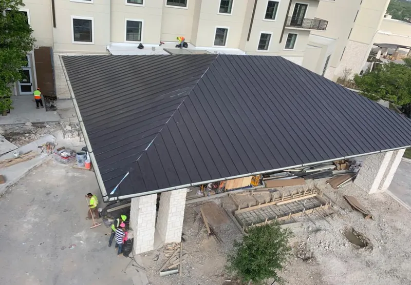 Metal roofing installation team working on a commercial building in St. Cloud
